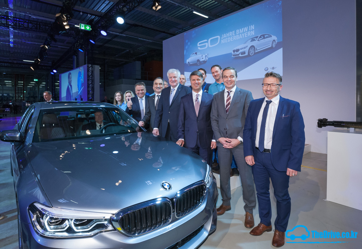BMW ±×·ì Ç϶öµå Å©·ç°Å ȸÀå(¿ìÃø¿¡¼ 3¹øÂ°)°ú ¹ÙÀÌ¿¡¸¥ÁÖ È£¸£½ºÆ® Á¦È£ÆÛ ÃѸ®(¿ìÃø¿¡¼ 4¹øÂ°)¸¦ ºñ·ÔÇÑ °ü°èÀÚµéÀÌ µù°ñÇÎ °øÀåÀÇ Ãµ¸¸ ¹øÂ° »ý»êÀÎ BMW ´º 5½Ã¸®Áî ¾Õ¿¡¼ Æ÷Á ÃëÇϰí ÀÖ´Ù.