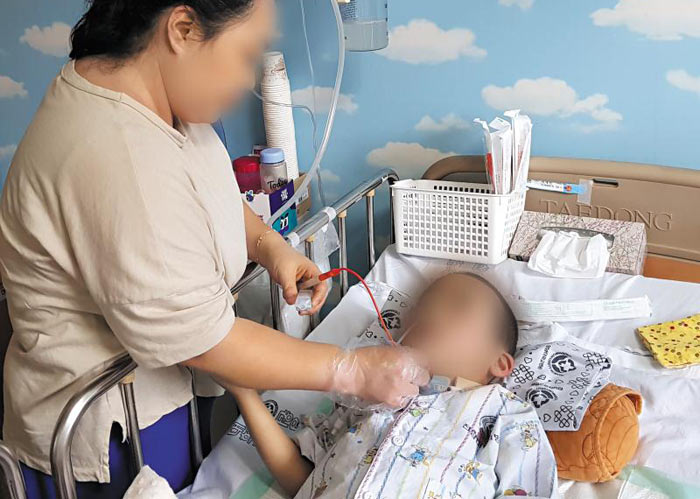 지난해 7월 불볕더위 속 찜통이 된 유치원 통학버스에 방치돼 의식 불명 상태에 빠진 최모(5)군의 코에 어머니 이모(38)씨가 튜브를 꽂아 음식물을 공급하고 있다. 최군의 시선은 허공을 향하고 있다. /김성현 기자
