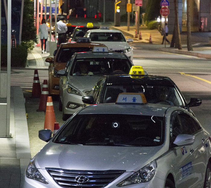 지난 14일 서울 중구 을지로의 한 이면 도로에 택시들이 ‘빈 차’ 표시등을 꺼놓고 대기 중이다. 모바일 택시 앱 ‘카카오택시’를 이용해 장거리 이동하는 손님을 골라 태우는 택시들이 많다고 한다. 먼 거리의 번화가로 이동하는 손님을 골라 태우기 위해 20분 이상 기다리는 경우도 있다. /성형주 기자