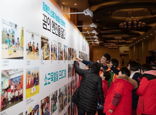SSCL '꿈의 엔진을 달다' 프로젝트의 2019년 송년 행사에 참가한 프로젝트 수혜자들이 소근육 발달 프로그램 참여 사진을 관람하고 있다. / 스투트가르트스포츠카(주) 제공